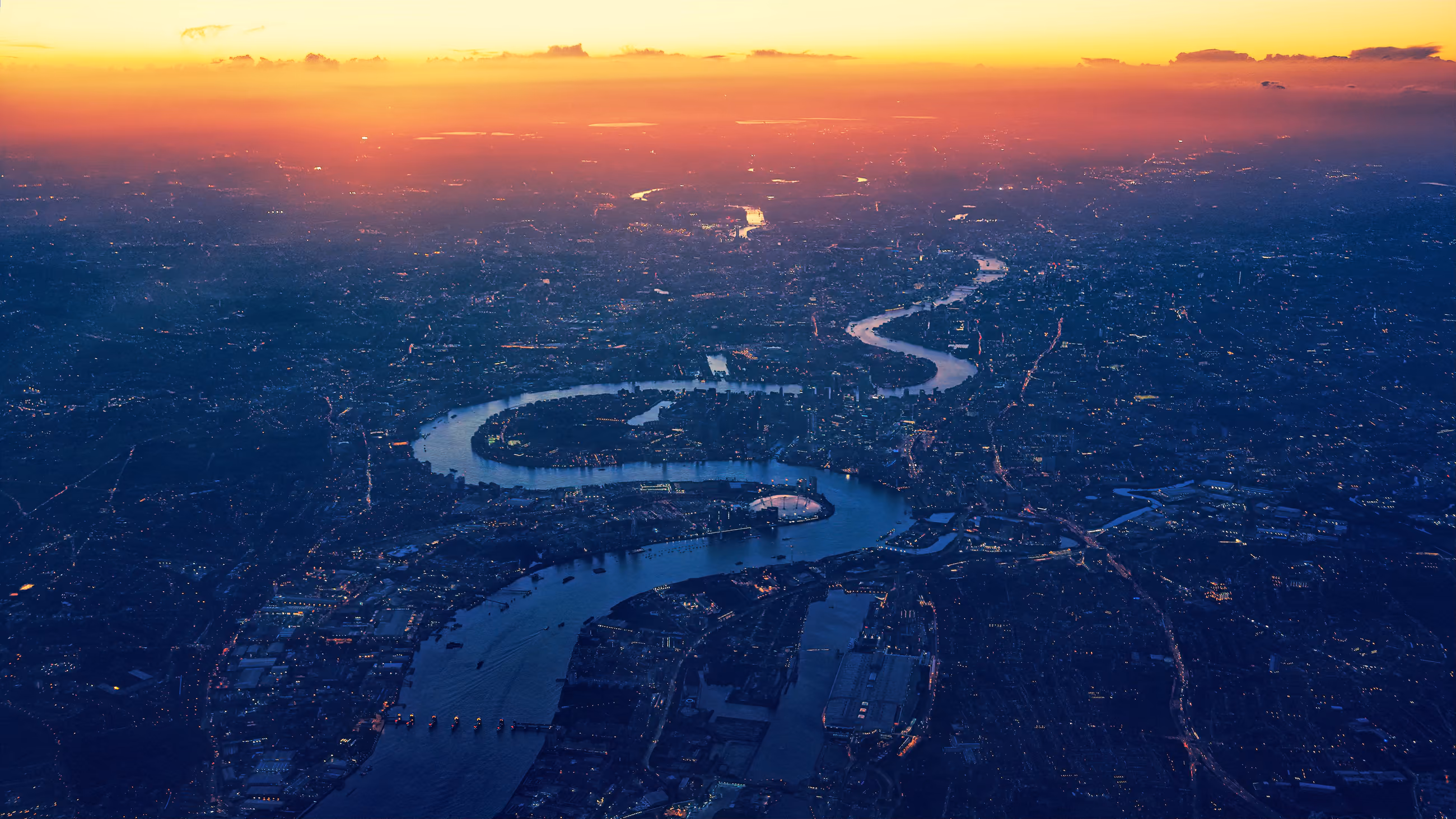 Aerial view of the Thames winding round the Isle of Dogs in East London at dusk